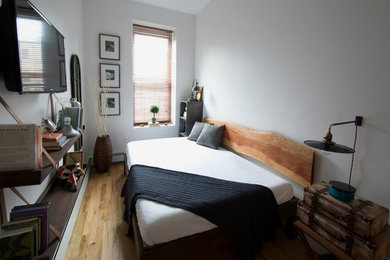 Ejemplo de habitación de invitados ecléctica pequeña sin chimenea con paredes blancas, suelo de madera clara y suelo marrón