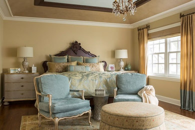 Diseño de dormitorio principal clásico con paredes beige, suelo de madera en tonos medios y suelo marrón