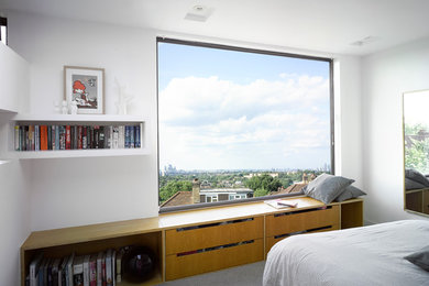 Medium sized modern bedroom in London with white walls, carpet and grey floors.