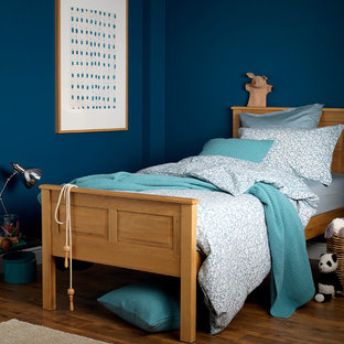 Modelo de dormitorio contemporáneo con suelo de madera en tonos medios