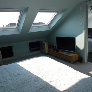 Ejemplo de dormitorio tipo loft, moderno, de tamaño medio, sin chimenea, con paredes azules y moqueta