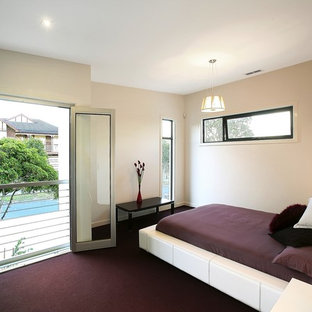 Modelo de dormitorio principal, minimalista, de tamaño medio, con paredes blancas, moqueta y suelo violeta