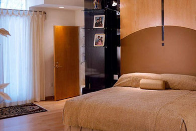 Modelo de dormitorio principal minimalista de tamaño medio sin chimenea con paredes blancas, suelo de madera clara y suelo beige