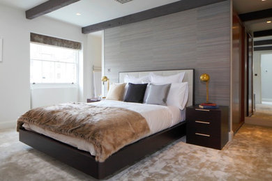 ロンドンにある中くらいなコンテンポラリースタイルのおしゃれな客用寝室 (カーペット敷き、ベージュの床、グレーの壁) のインテリア