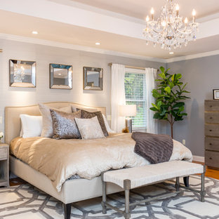 Example of a transitional master medium tone wood floor and brown floor bedroom design in New York with gray walls
