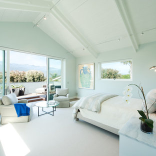 This is an example of a large beach style master bedroom in Santa Barbara with grey walls, medium hardwood floors, no fireplace and brown floor.