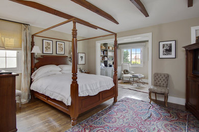 Ejemplo de dormitorio tradicional con paredes beige, suelo de madera en tonos medios y suelo marrón