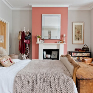 Modelo de dormitorio principal, romántico, de tamaño medio, con paredes rosas, moqueta, chimenea tradicional, marco de chimenea de madera y suelo beige