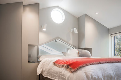 This is an example of a small contemporary master bedroom in London with grey walls.