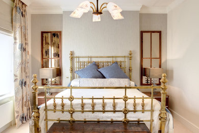 This is an example of a contemporary master bedroom in London with beige walls, carpet and no fireplace.