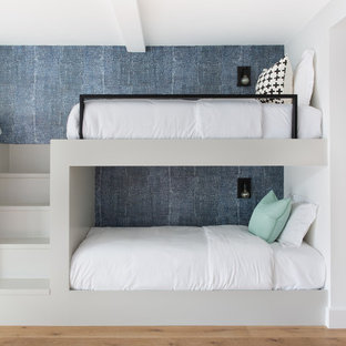 Ejemplo de dormitorio tipo loft, contemporáneo, de tamaño medio, sin chimenea, con paredes multicolor y suelo de madera en tonos medios
