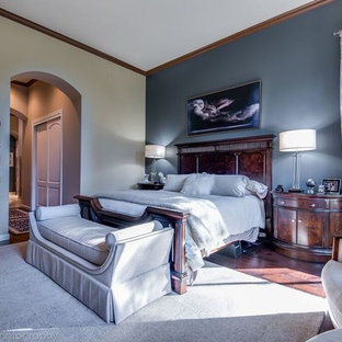Imagen de dormitorio principal, clásico renovado, de tamaño medio, con paredes azules, suelo de madera oscura, chimenea tradicional y marco de chimenea de madera