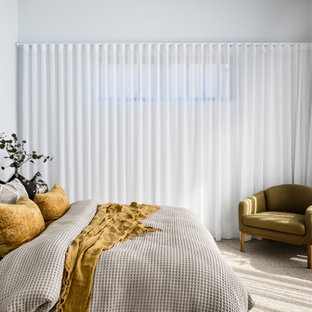 Contemporary bedroom in Brisbane with white walls, carpet and grey floor.