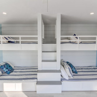 Ejemplo de habitación de invitados costera, de tamaño medio, con paredes azules, suelo vinílico y suelo gris