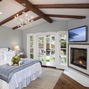 Mittelgroßes Klassisches Hauptschlafzimmer mit Eckkamin, grauer Wandfarbe, dunklem Holzboden, gefliester Kaminumrandung und braunem Boden in San Diego