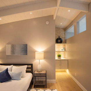 Idée de décoration pour une chambre d'amis vintage de taille moyenne avec un mur gris, un sol en bois clair et un sol marron.