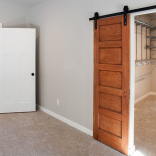Large traditional master bedroom in Seattle with grey walls, carpet and grey floor.