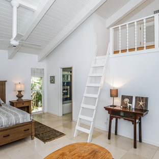 Ejemplo de dormitorio tipo loft, exótico, sin chimenea, con paredes blancas y suelo beige