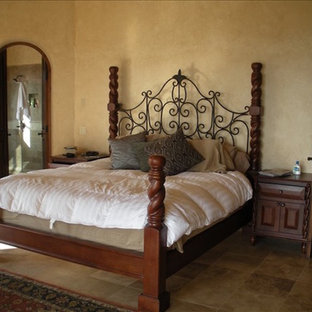 Modelo de dormitorio tipo loft, de estilo americano, de tamaño medio, con paredes amarillas y suelo de baldosas de terracota