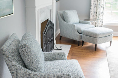 This is an example of a medium sized rural master and grey and silver bedroom in Dallas with a standard fireplace, a stone fireplace surround, brown floors, grey walls and medium hardwood flooring.