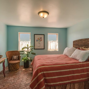 Modelo de habitación de invitados de estilo americano, de tamaño medio, sin chimenea, con paredes azules, suelo de ladrillo y suelo rojo