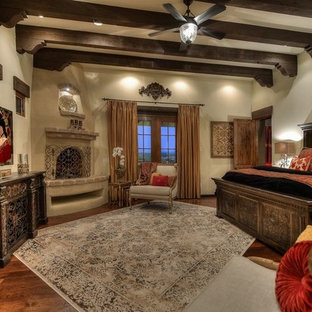 Diseño de dormitorio principal, mediterráneo, extra grande, con paredes beige, suelo de madera oscura, chimenea de esquina y marco de chimenea de hormigón