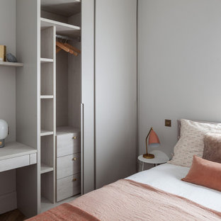 Photo of a contemporary bedroom with grey walls, dark hardwood flooring and brown floors.