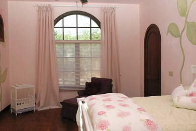 Imagen de habitación de invitados clásica de tamaño medio sin chimenea con paredes rosas y suelo de madera oscura