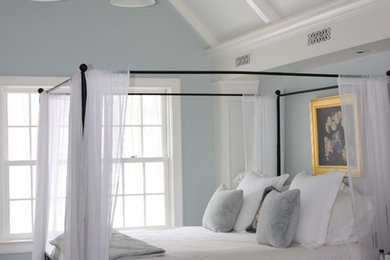 Modelo de dormitorio principal clásico renovado grande con paredes azules, suelo de madera oscura, todas las chimeneas y marco de chimenea de baldosas y/o azulejos