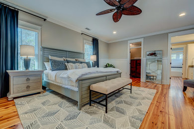 Foto de dormitorio principal tradicional renovado grande sin chimenea con paredes beige, suelo de madera en tonos medios y suelo marrón