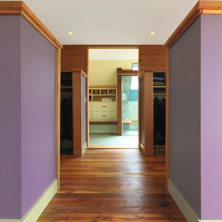 Modelo de dormitorio principal, rústico, grande, con paredes púrpuras y suelo de madera oscura
