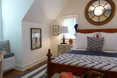 Diseño de dormitorio tipo loft tradicional renovado pequeño con paredes blancas y suelo de madera en tonos medios