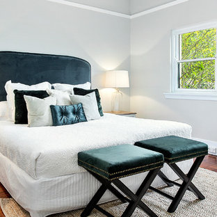 Photo of a mid-sized transitional master bedroom with grey walls, medium hardwood floors and brown floor.