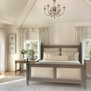 Exemple d'une chambre parentale romantique avec un mur beige et un sol en bois brun.