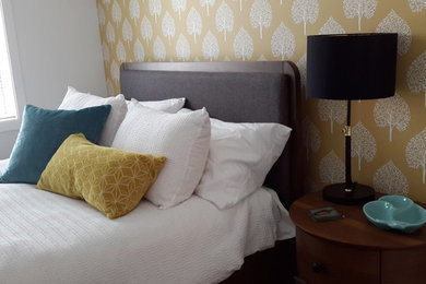 Modernes Hauptschlafzimmer mit gelber Wandfarbe, Teppichboden und beigem Boden in Sonstige
