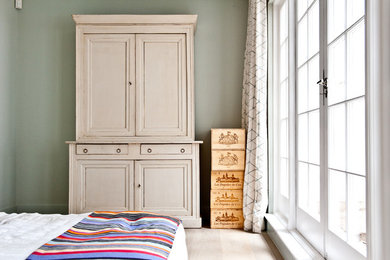 This is an example of a medium sized contemporary guest bedroom in London with grey walls and light hardwood flooring.