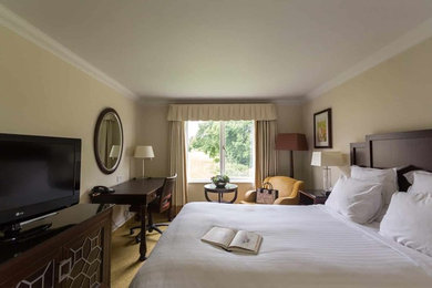Imagen de habitación de invitados actual de tamaño medio con paredes beige y con escritorio