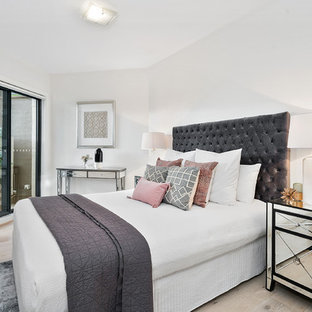 This is an example of a small transitional master bedroom in Sydney with white walls, light hardwood floors and beige floor.