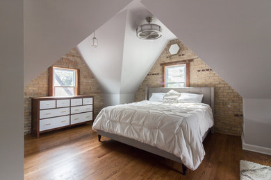 Transitional master medium tone wood floor and brown floor bedroom photo in Chicago with gray walls