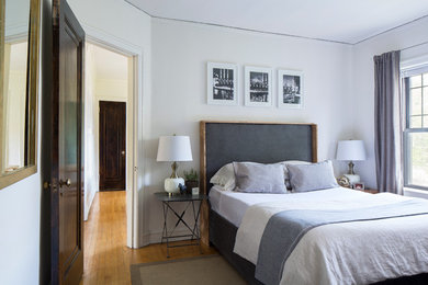 Ejemplo de dormitorio principal contemporáneo pequeño sin chimenea con paredes blancas y suelo de madera en tonos medios