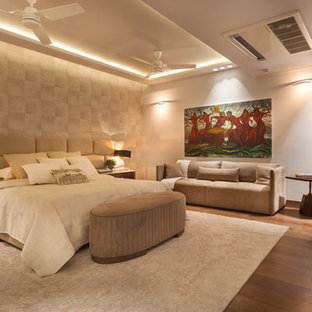 Foto de dormitorio actual, grande, con paredes beige y suelo de madera en tonos medios