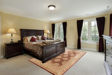 ワシントンD.C.にある広いトラディショナルスタイルのおしゃれな主寝室 (黄色い壁、カーペット敷き、グレーの床) のインテリア