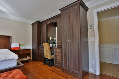 Modelo de habitación de invitados tradicional de tamaño medio sin chimenea con paredes beige, suelo de madera en tonos medios y suelo marrón