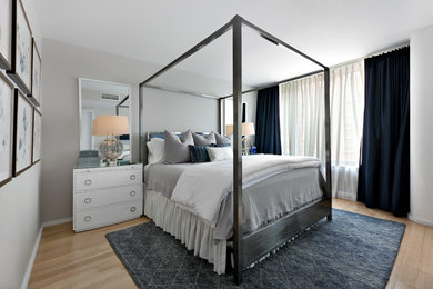Diseño de dormitorio principal clásico renovado de tamaño medio sin chimenea con paredes grises, suelo de madera clara y suelo marrón