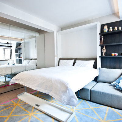 Small trendy master medium tone wood floor bedroom photo in London with gray walls and no fireplace