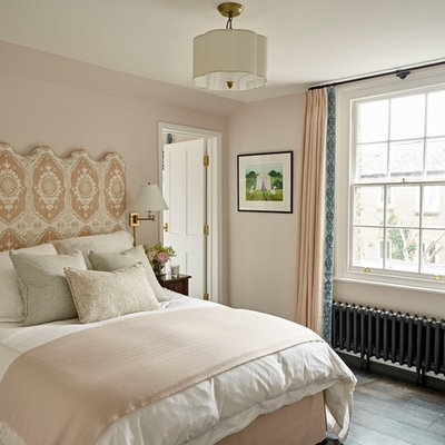 Mid-sized elegant guest dark wood floor and brown floor bedroom photo in London with beige walls