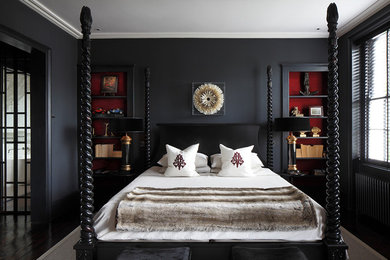 Traditional bedroom in London with black walls and dark hardwood flooring.