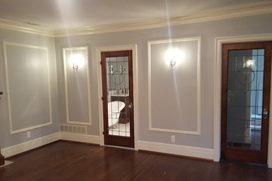 Example of a large classic master medium tone wood floor and brown floor bedroom design in Detroit with gray walls, a standard fireplace and a wood fireplace surround