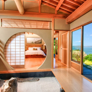 Diseño de dormitorio principal, asiático, grande, con paredes beige y suelo de madera clara