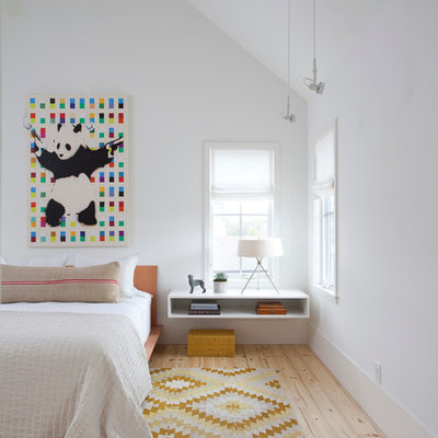 Example of a danish master light wood floor bedroom design in Austin with no fireplace and white walls